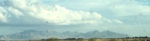 A distant mountain range on the left under a vast sky, representing enduring strength and divine guidance on life's journey.