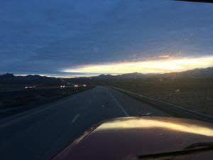 A beautiful distant mountain view on the left side of the road under a clear sky.