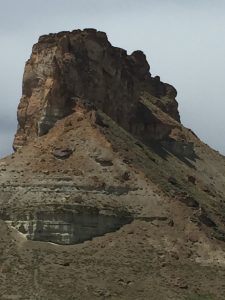A beautiful photograph showing a massive rock mountain that rises as its own big, towering stone structure without spreading out wide from side to side.